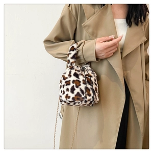 Detail of leopard print plush bucket bag featuring drawstring closure and metal chain