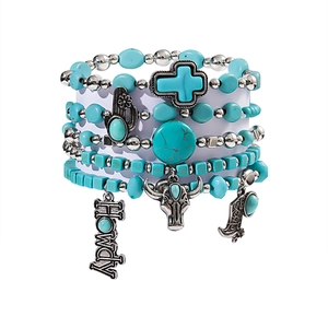Detail of bohemian turquoise stretch bracelet set featuring silver charms like bull and cactus