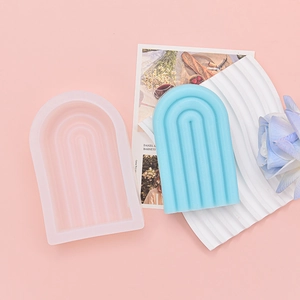 Détail macro du moule en silicone arc-en-ciel avec rayures verticales et bougie bleue terminée