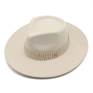 Detail of wool fedora hat with houndstooth band and golden M emblem on the brim