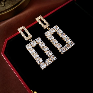 Close-up of geometric square earrings with sparkling cubic zirconia in gold plating