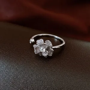 Elegant silver zircon flower open ring with sparkling petals on dark leather background