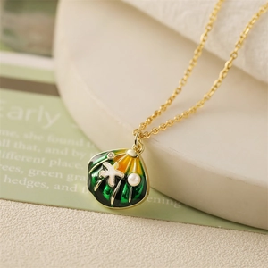 Close-up of shell pendant with green and yellow enamel and small starfish detail