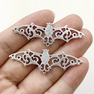 56mm silver filigree bat pendants in hand for DIY jewelry and accessory making