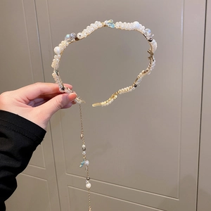 Detail of gold pearl headband featuring colorful beads and long hanging fringe tassels