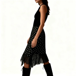 Detailed view of black polka dot skirt featuring delicate lace trim and matching tall boots