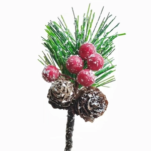 Close-up of frosted pine needles with red berries and natural pine cones with fake snow