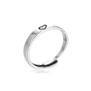 Detail view of silver heart pattern open ring with metallic luster and subtle reflection