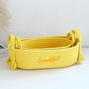 Detail of yellow oval woven baskets with tassels and embroidered beautiful text