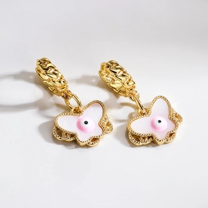 Gold butterfly earrings with pink eye detail and white enamel charms on circular hoops