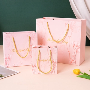 Elegant pink gift bags with gold handles and leaf patterns in three different sizes