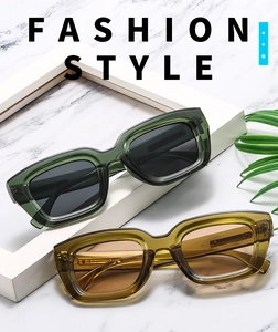 Close-up of stylish square frame sunglasses in transparent olive green and amber shades