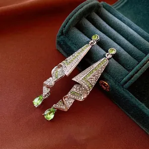 Elegant silver drop earrings with emerald green rhinestones on velvet jewelry box