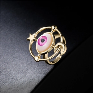 Golden evil eye ring with cosmic moon and star elements on a black background