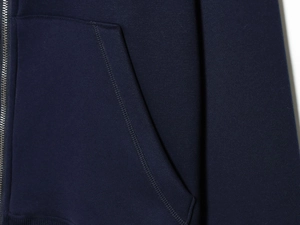 Detail of navy blue hoodie showing durable zipper and reinforced side pocket stitching