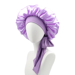 Detail of purple satin sleep bonnet featuring elastic headband and long adjustable ribbon