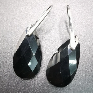 Detailed view of black faceted teardrop crystal earrings with silver metal hooks