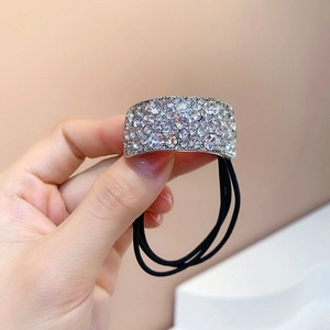 Gros plan sur l'attache-queue de cheval de luxe avec strass étincelants et élastique noir