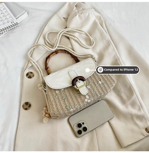 Detailed comparison of the embroidered straw handbag size against an iPhone 12