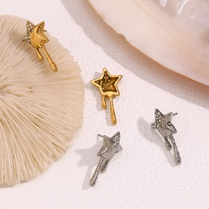 Macro shot of gold and silver melting star stud earrings with white rhinestones