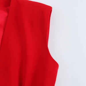 Close-up of red sleeveless top detailing the smooth woven fabric on shoulder and armhole