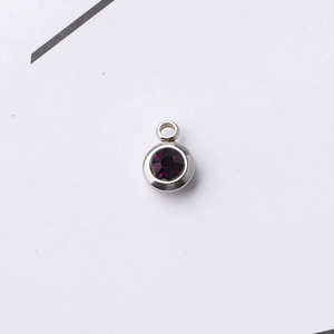 Macro shot of 6.5mm stainless steel pendant with dark purple faceted birthstone gem