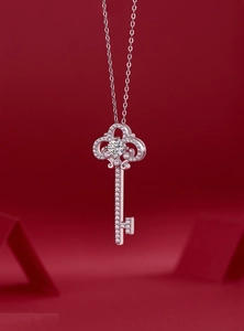 Detailed view of a silver crown key pendant with sparkling round moissanite