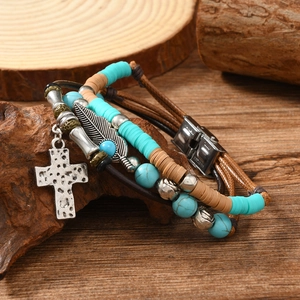 Detailed view of layered leather bracelet with turquoise beads and feather cross charms