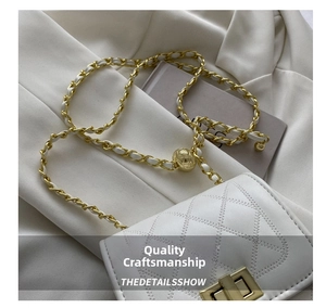 Detail of white quilted chain bag with gold adjustable ball buckle and woven strap