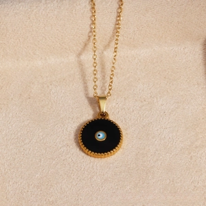 Close-up of titanium steel evil eye pendant with blue eye pattern and gold beaded edge