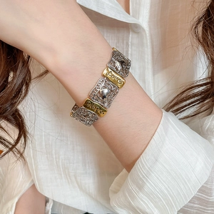 Detail of vintage heart-patterned metal bracelet with Love and Hope engraving