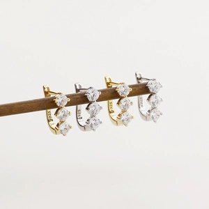 Detailed macro view showing S925 hallmark on U-shaped silver earrings with cubic zirconia