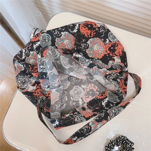 Detail view of large floral print cotton tote bag with wide straps on white background