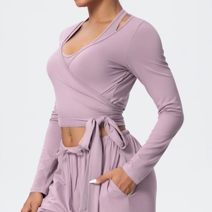 Detail of cross-wrap long sleeve yoga top with adjustable side ties in dusty rose color