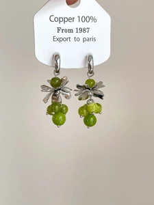 Detail of silver C-shape flower earrings with green crystal grape tassels and copper petals