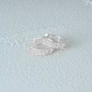 Macro shot of S925 sterling silver stamp and diamond inlay on silver hoop earring