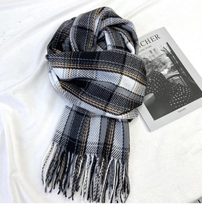 Close-up of thick plaid scarf featuring soft cashmere-like texture and classic long tassels