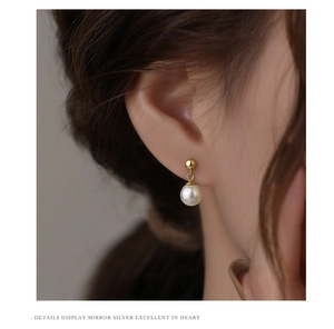 Elegant pearl drop earring worn on model showing the polished metallic finish and details