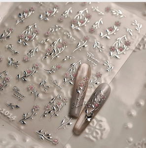 Detalle macro de pegatinas de uñas de hojas de plata y flores en uñas