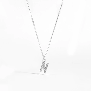 Detailed view of silver necklace featuring a crystal-paved letter N initial pendant