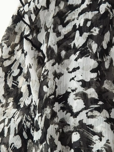 Detaillierte Nahaufnahme von Chiffonstoff mit abstrakten schwarz-weißen Batik-Druckmustern