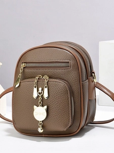 Brown litchi leather mini backpack with gold zippers and white cat charm pendant