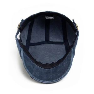 Inside view of washed cotton newsboy cap showing blue fabric and 100% cotton label