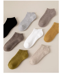 Flat lay of eight pairs of cotton low cut sports socks in assorted solid neutral colors