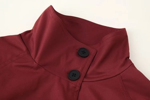 Détail du col croisé bordeaux profond avec boutons noirs et texture en coton sergé