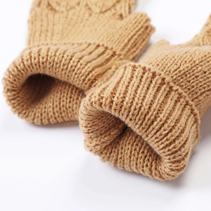 Detailed close-up of thick ribbed cuffs on camel knitted wool fingerless gloves