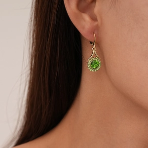 Close-up of a leverback earring featuring a large green crystal circled by small rhinestones