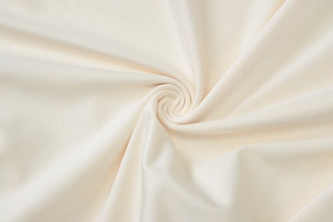 Detailed macro view of beige knitted rib fabric showing soft texture and twisted drape detail