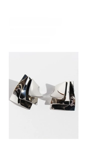 Macro detail of geometric silver layered metal earrings with irregular mirror finish texture