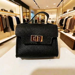 Detailed view of black litchi grain leather mini bag with gold-tone hardware and clasp